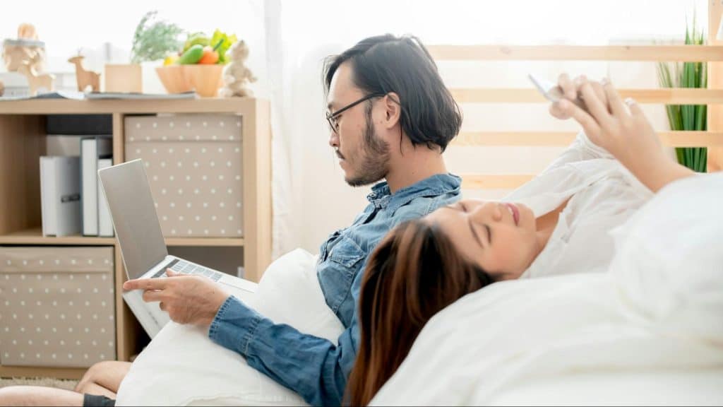 A man and woman busy with their gadgets