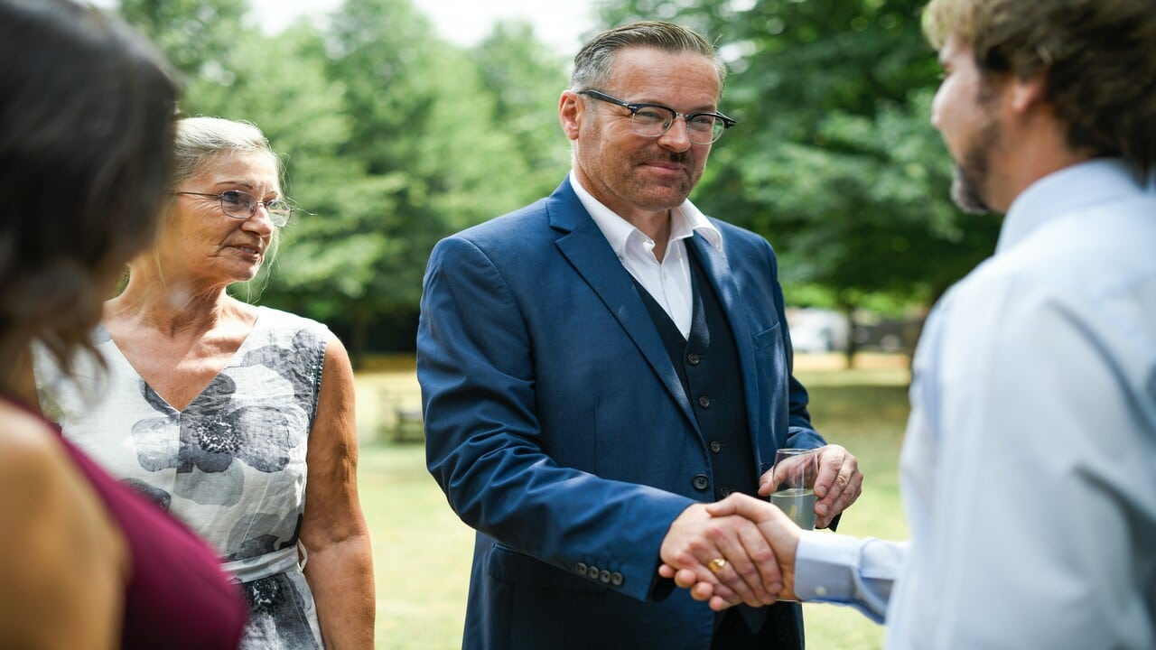 An older man greeting his new son-in-law