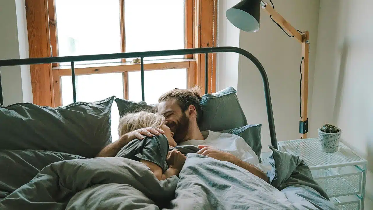 A couple cuddling together in bed