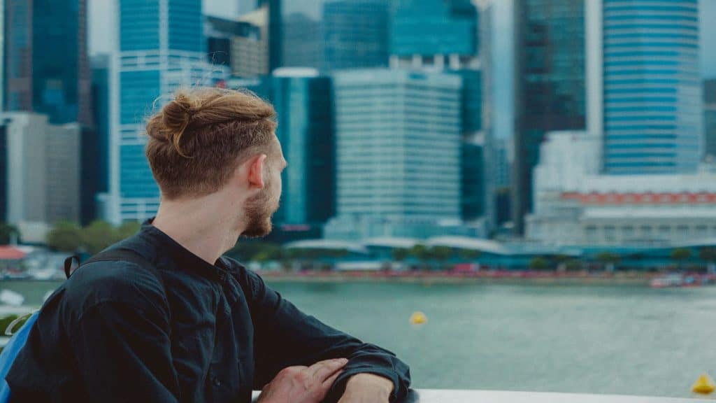 man looking thoughtfully at city skyline