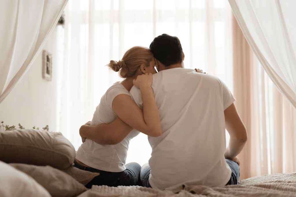 Couple in bed sitting and hugging each other