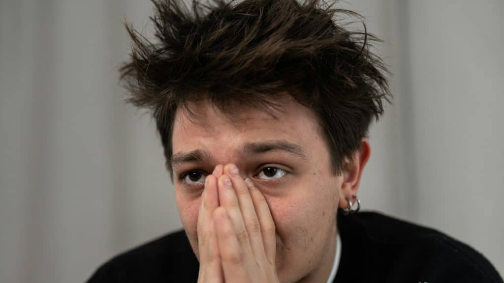 A man covers his face with his hands.
