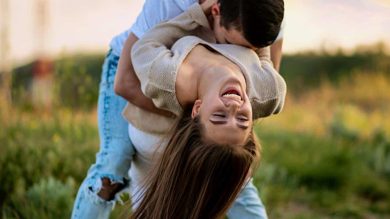 A man playfully dipping a laughing woman