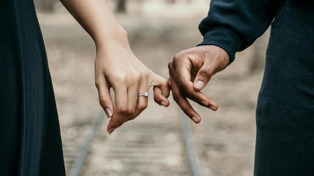 A couple linking pinky fingers