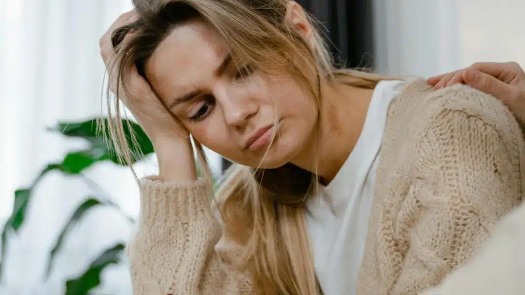A sad woman resting her head on her hand