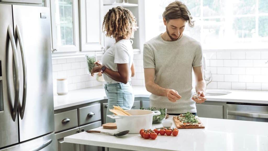 A couple preparing a meal together in a bright, modern kitchen.