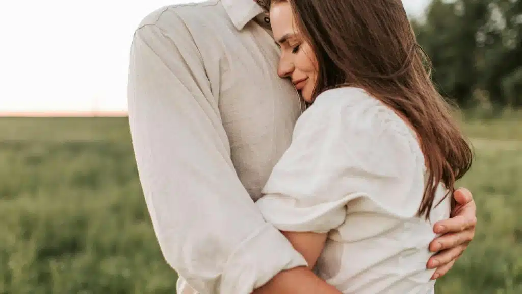 A woman hugging a man outdoors