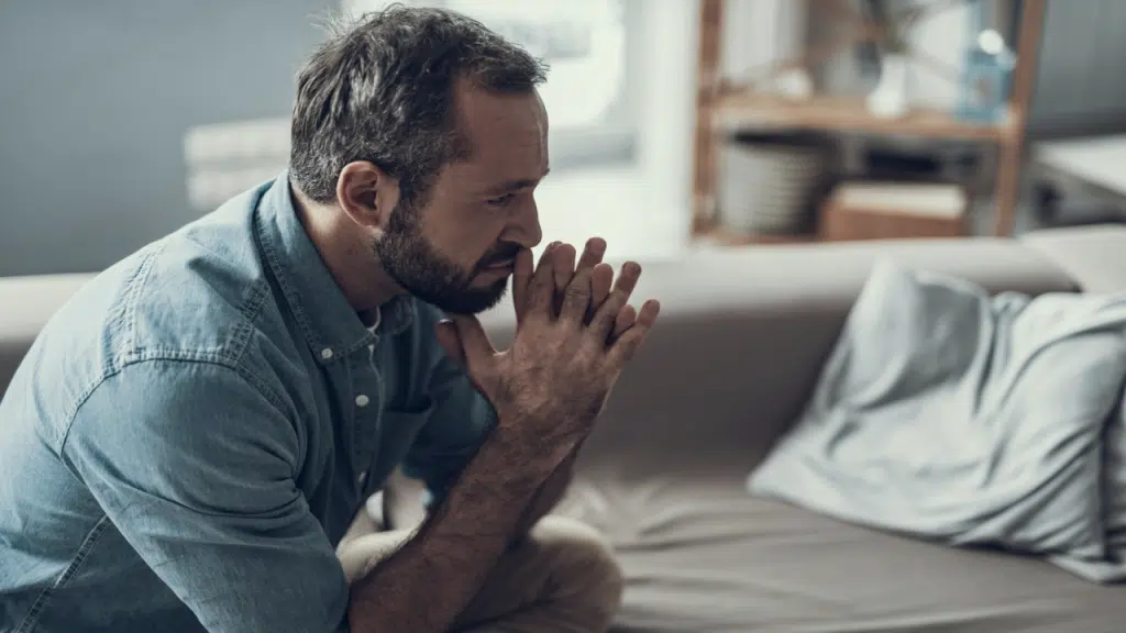 A man looking sad and thoughtful at home