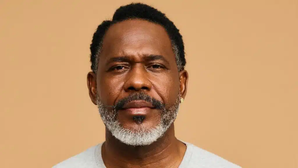 A mature bearded man looking at the camera with a serious expression.