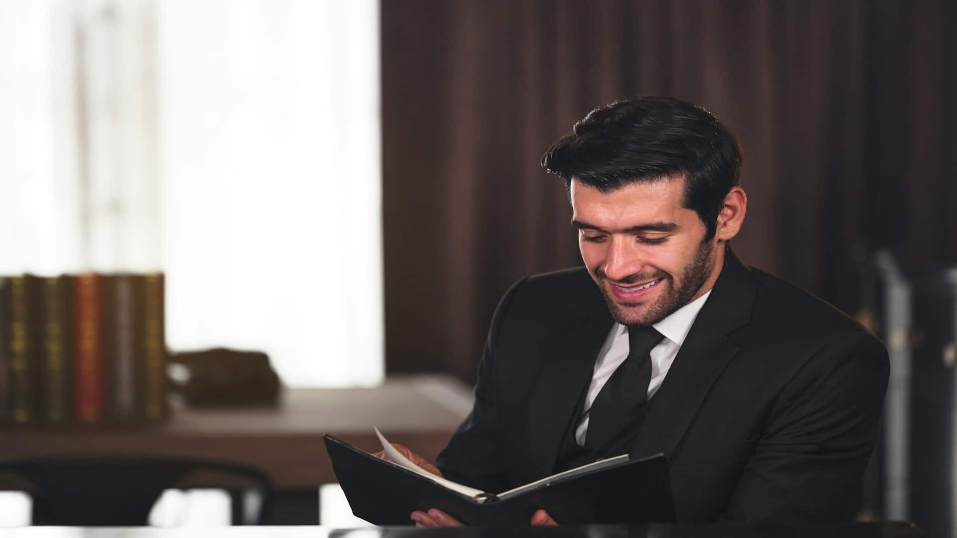 man smiling while reviewing budget