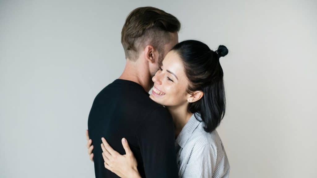 A man and a woman hugging each other.