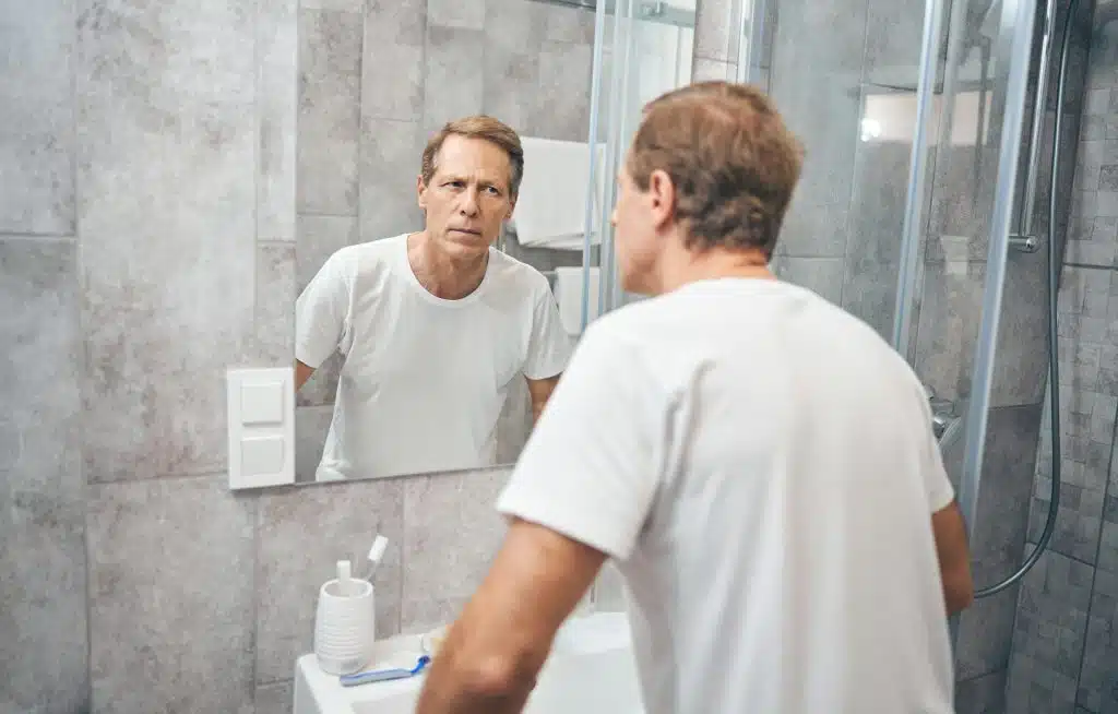 man reflective expression mirror