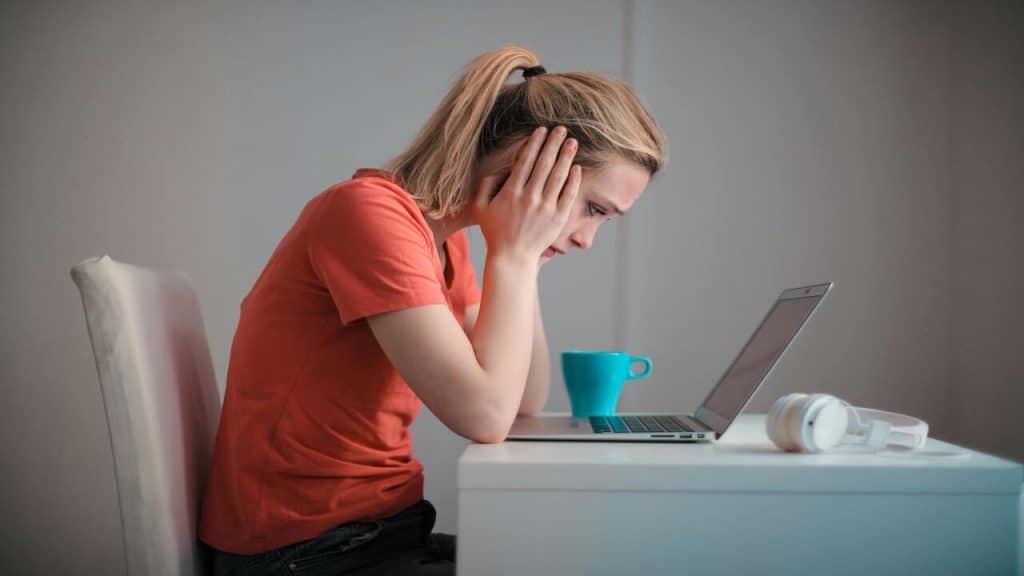 A woman looking sadly at her laptop