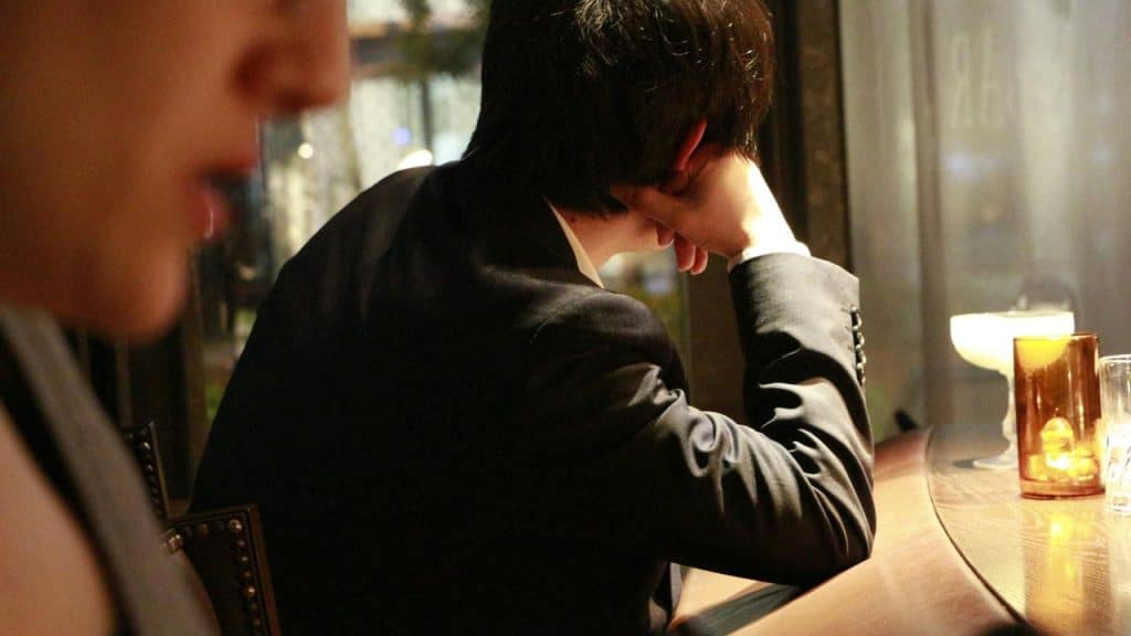 A man sitting at a bar with his head resting on his hand