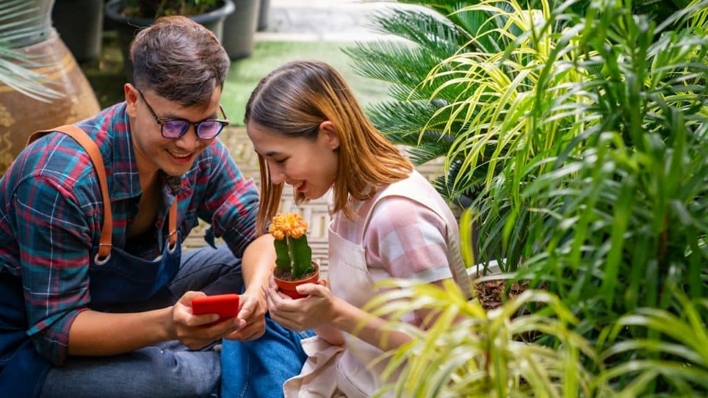 A man and a woman are live-streaming plants in their plant nursery.