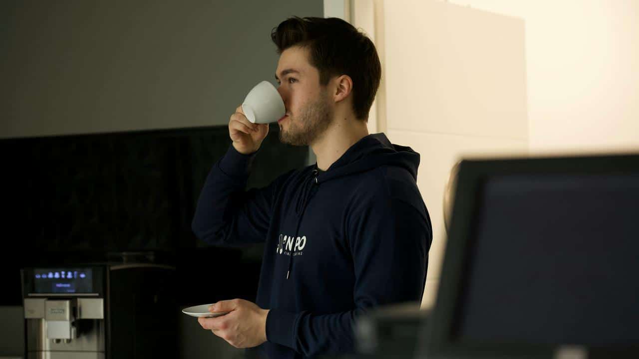 A man drinking coffee in a kitchen