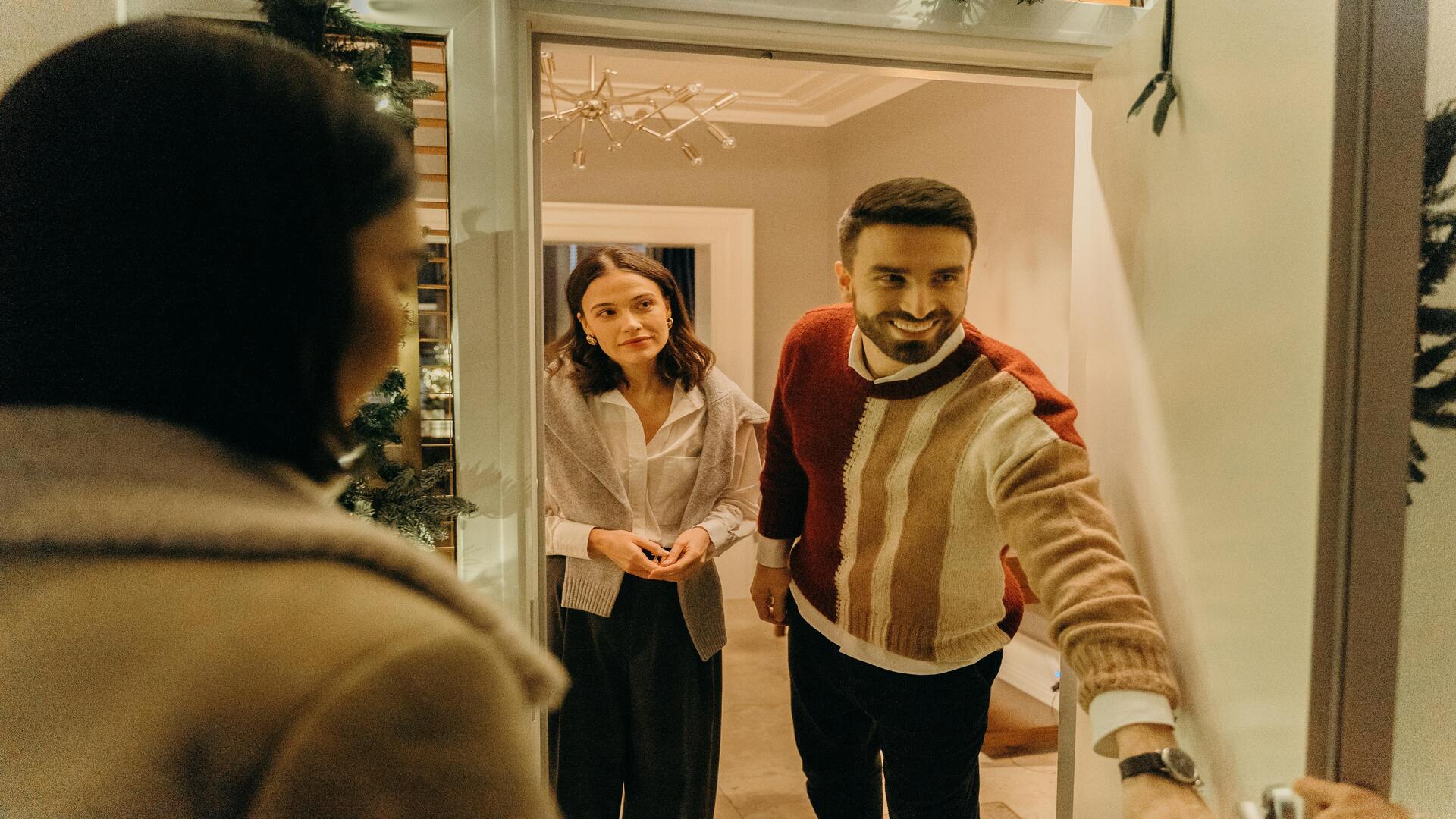 A couple welcoming their friends to their home