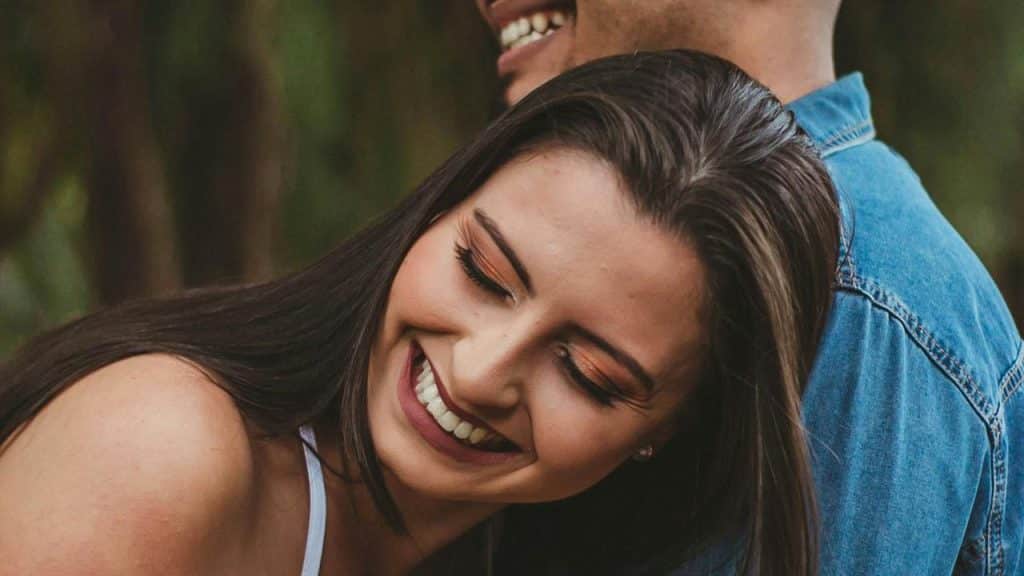 A smiling woman leaning against a man outdoors.You don't need to agree with everything she says. In fact, pretending to have the exact same opinions as her is one of the fastest ways to kill attraction. Women don't want a yes-man. They want someone with a backbone, someone who can hold their own in a conversation without folding at the first sign of disagreement.