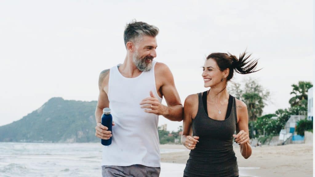 A couple jogging at a beach.