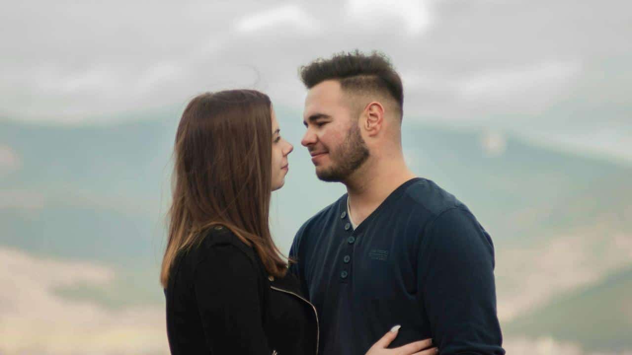 A man and a woman holding each other outdoors.