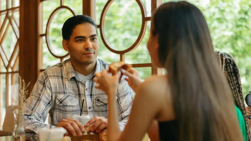 A man and woman sitting at a café table