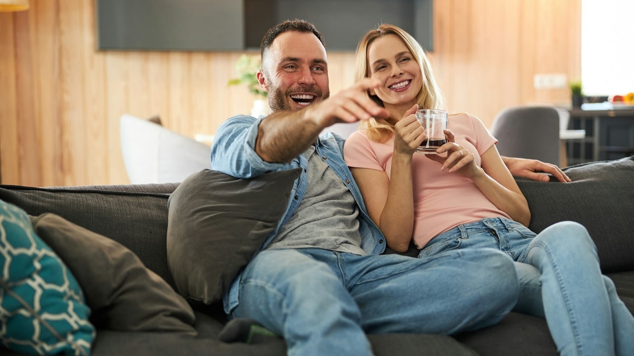 A couple watching tv together at home.