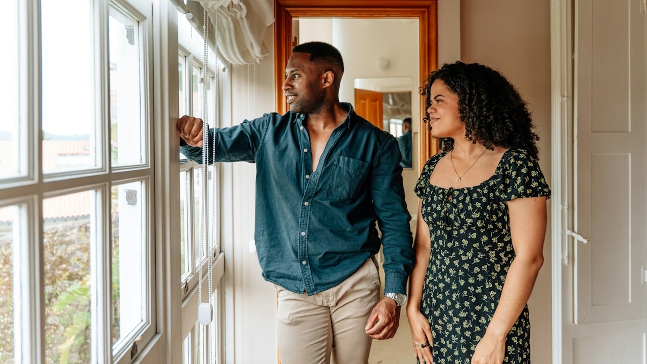 A couple looking outside a huge window.