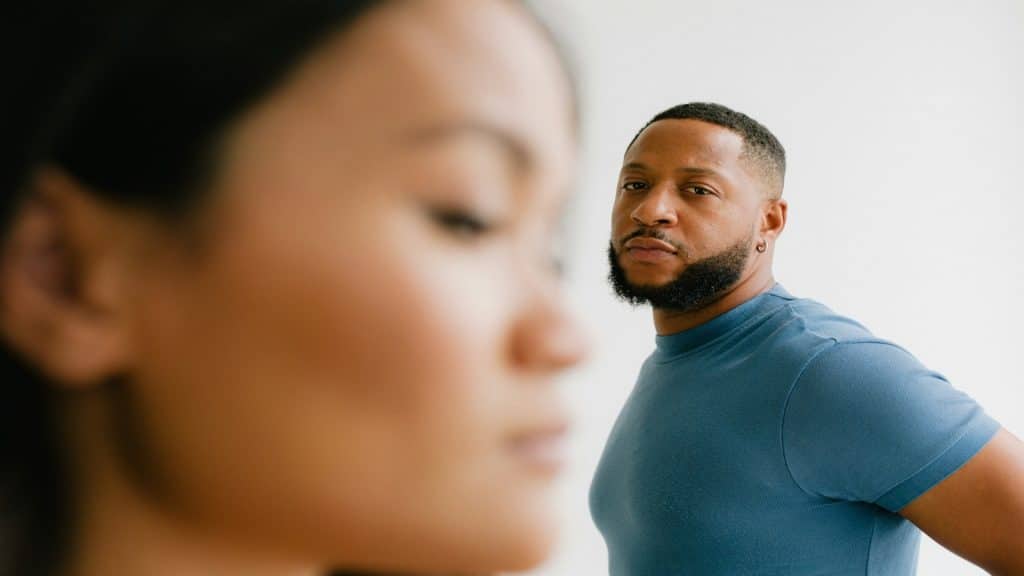 man looking unaware while partner looks thoughtful