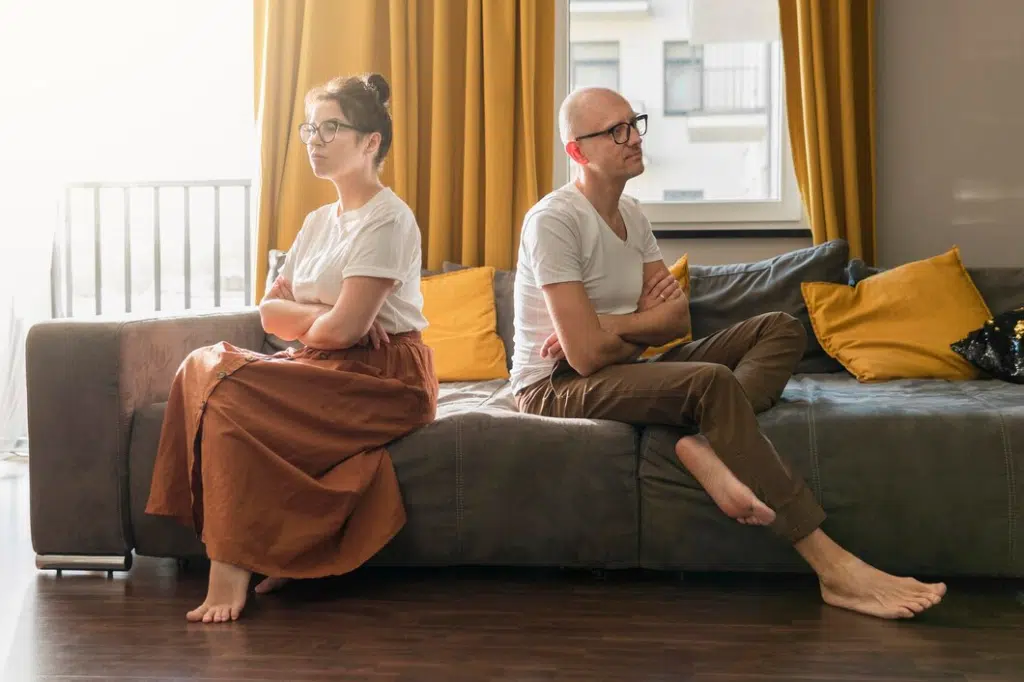 Problematic couple sitting apart on couch