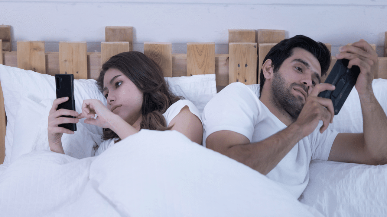 A couple using their phones at home