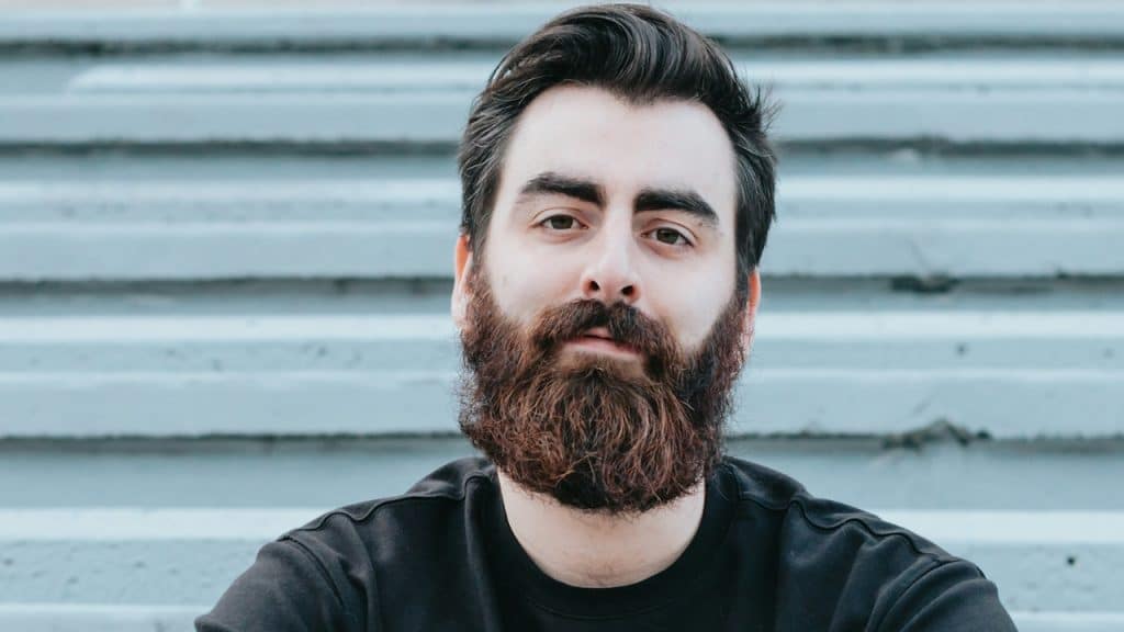 A close-up of a man with a beard looking at the camera.