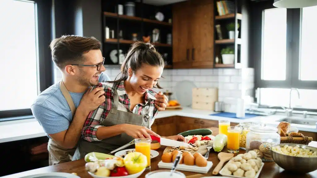 A couple laughing together in the kitchen