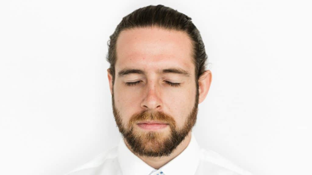 A close-up of a man with his eyes closed.