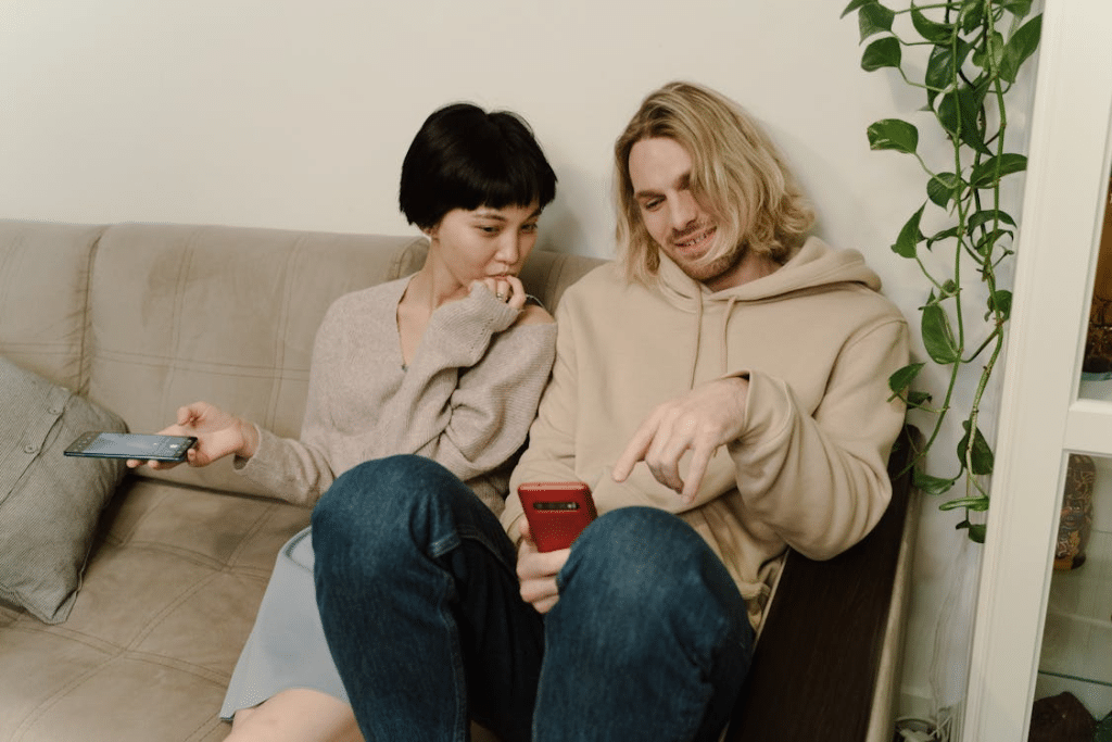 Close-Up Shot of a Man and Woman Looking at the Cellphone