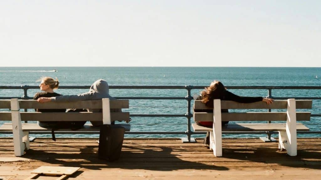 man sitting thoughtfully while couple talks