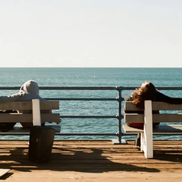 man sitting thoughtfully while couple talks