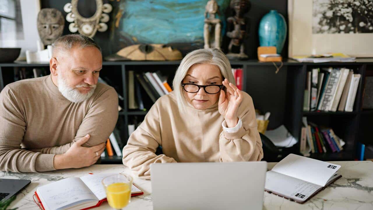A mature couple looking at their laptop