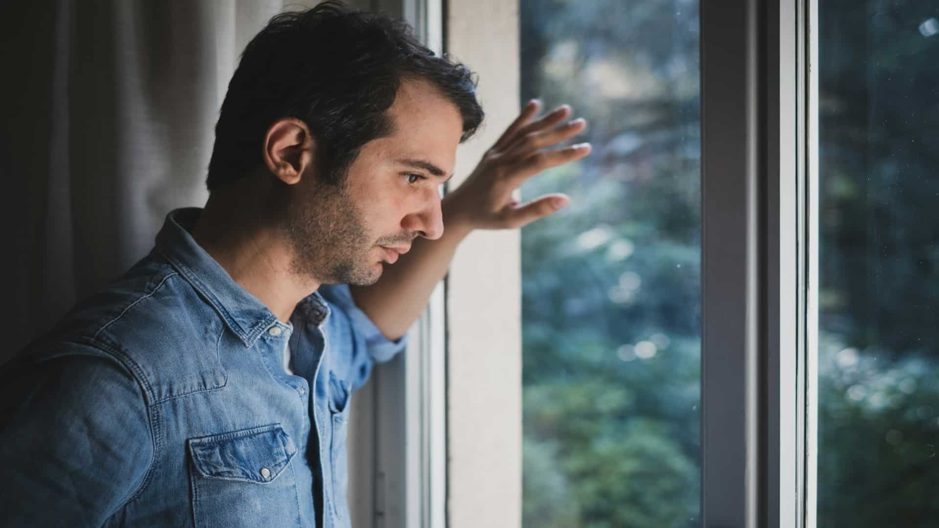 individual thinking near window