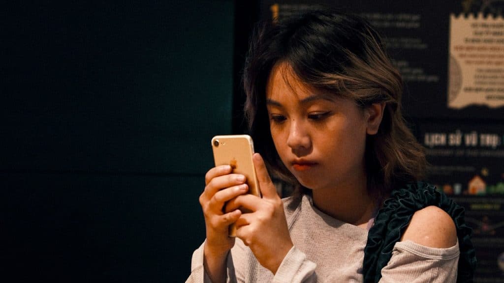A woman checking her cell phone while sitting.