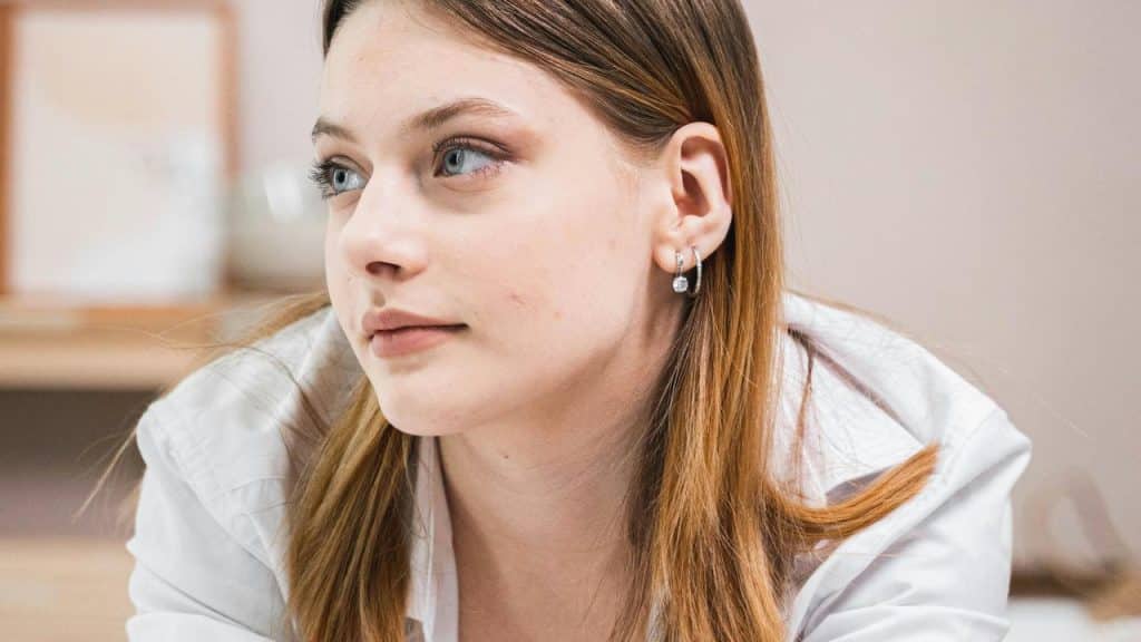 A woman looking to the side with a thoughtful expression.