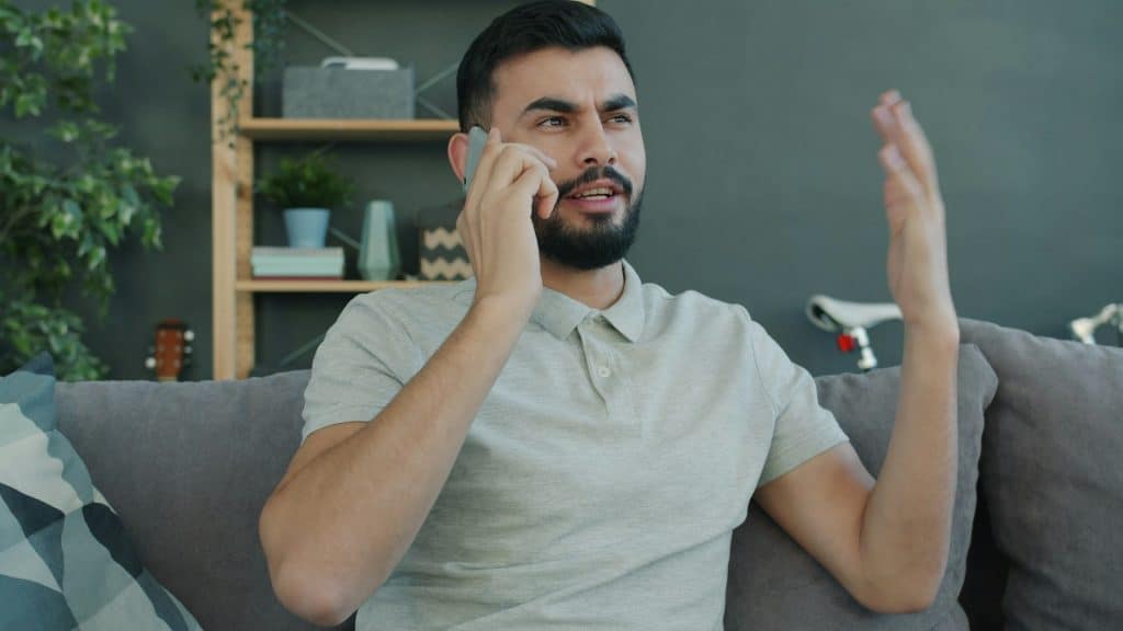 man looking at phone while partner talks