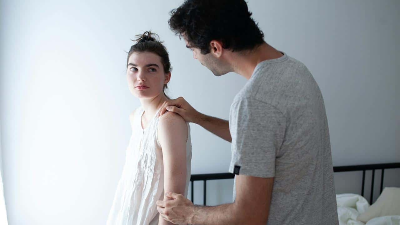 Man holding woman’s arm and console her.