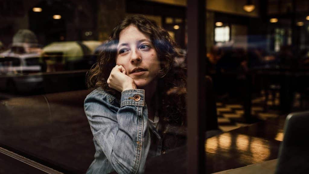 A woman sitting by a window in a cafe