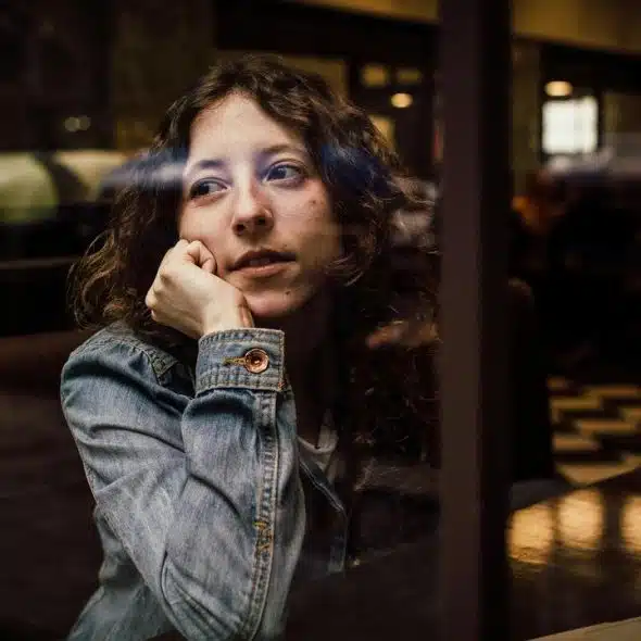 A woman sitting by a window in a cafe