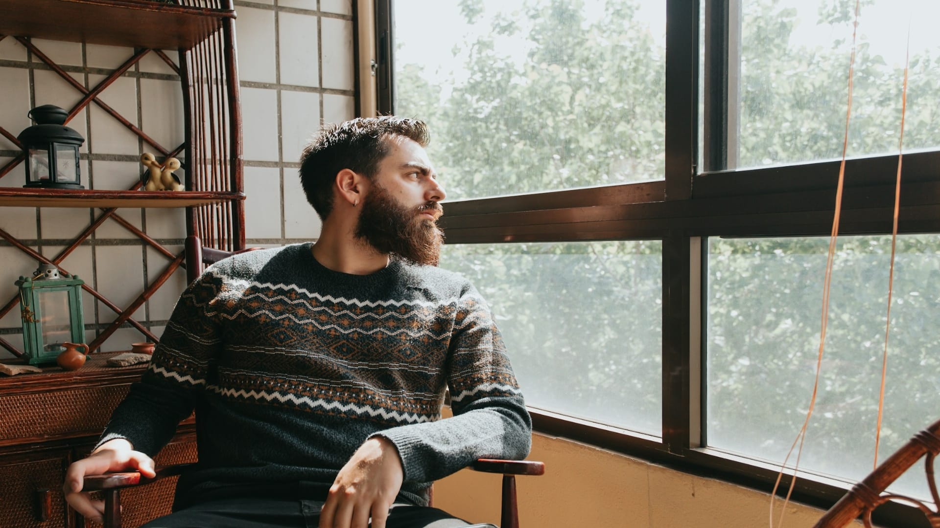 man sitting thoughtfully by window