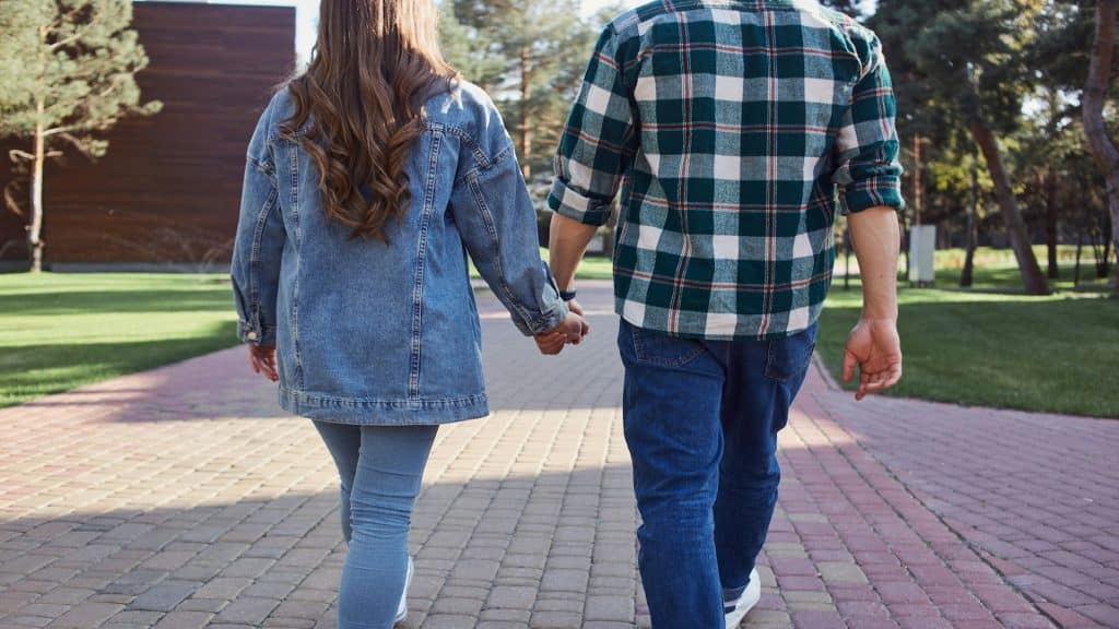 couple holding hands while walking