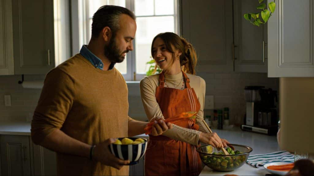 A man helping woman to prepare dinner