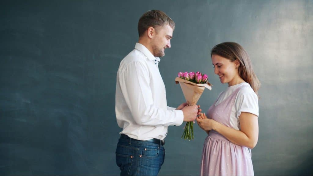 A man giving flowers to woman