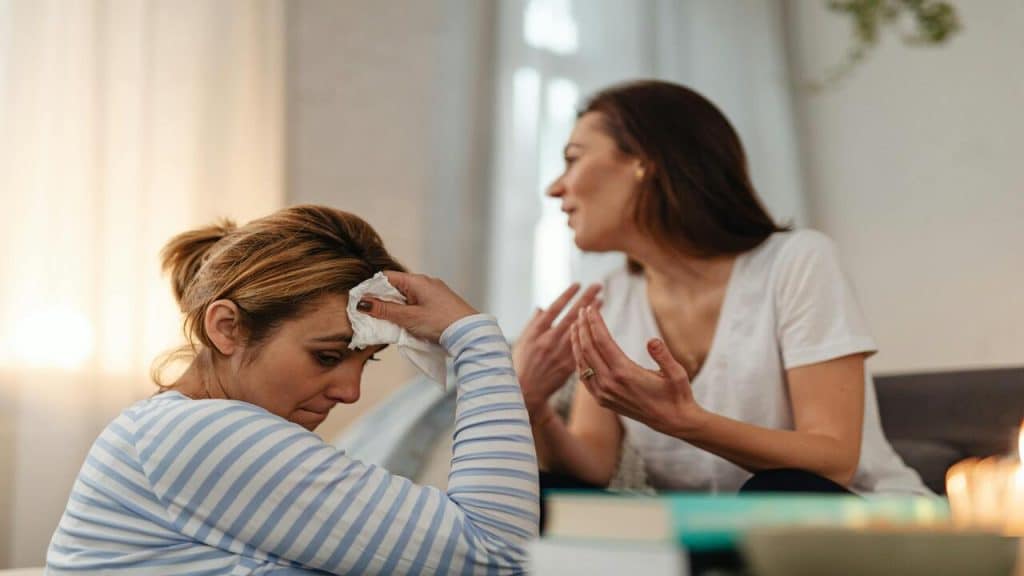 A woman looking sad while her friend talks
