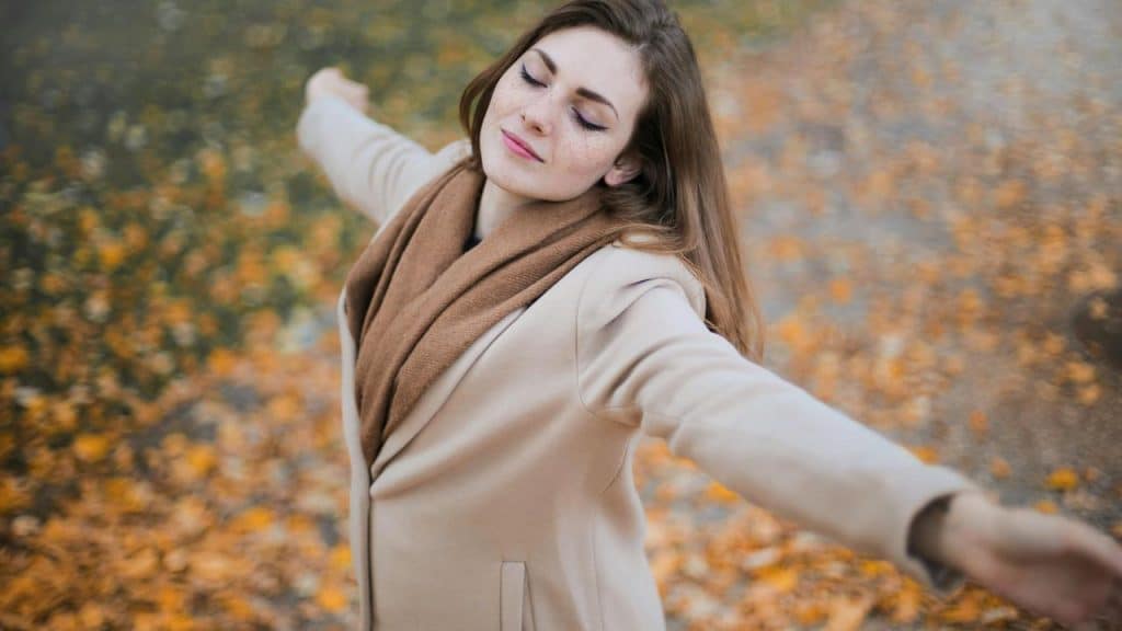 A woman enjoying a peaceful moment outdoors in autumn.